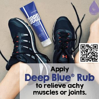 A tube of Ice Blue between a pair of feet wearing sneakers.