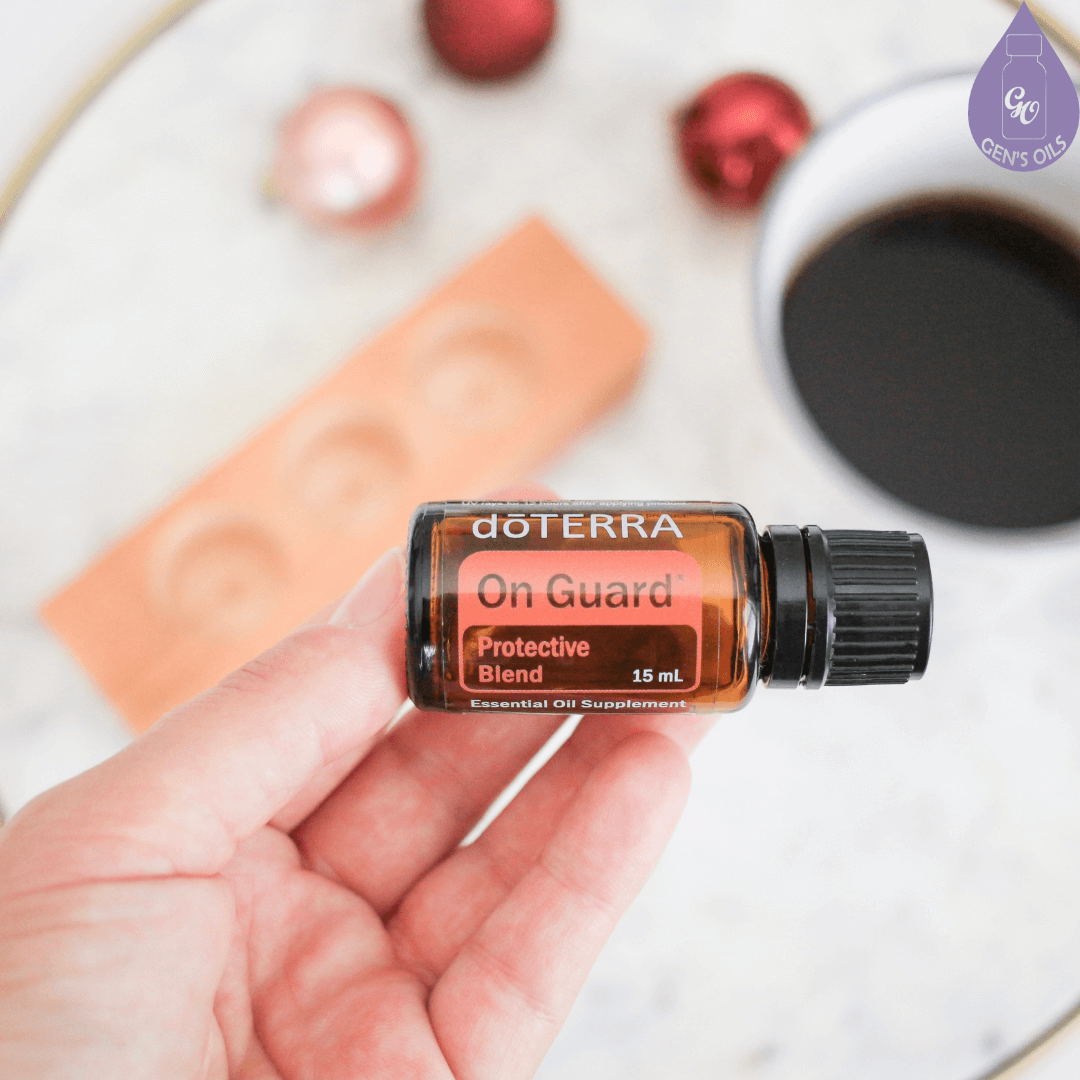 Hand holding a bottle of OnGuard essential oil.