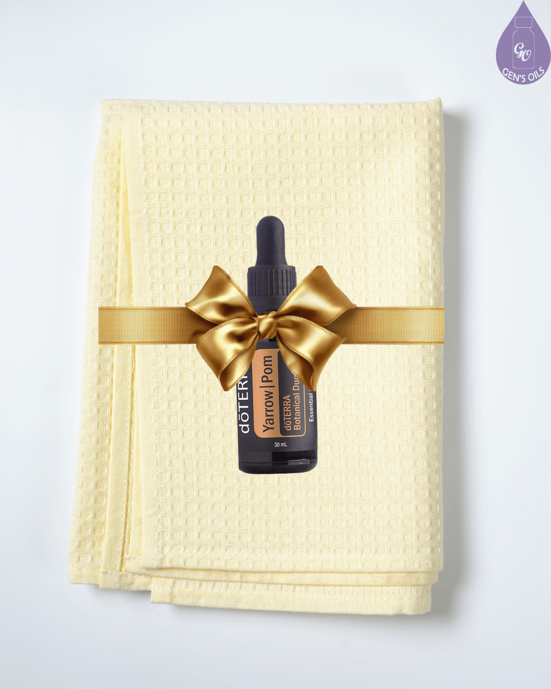 Glow to Go Set. A bottle of YarrowPom on a soft yellow facecloth, tied with a gold bow.