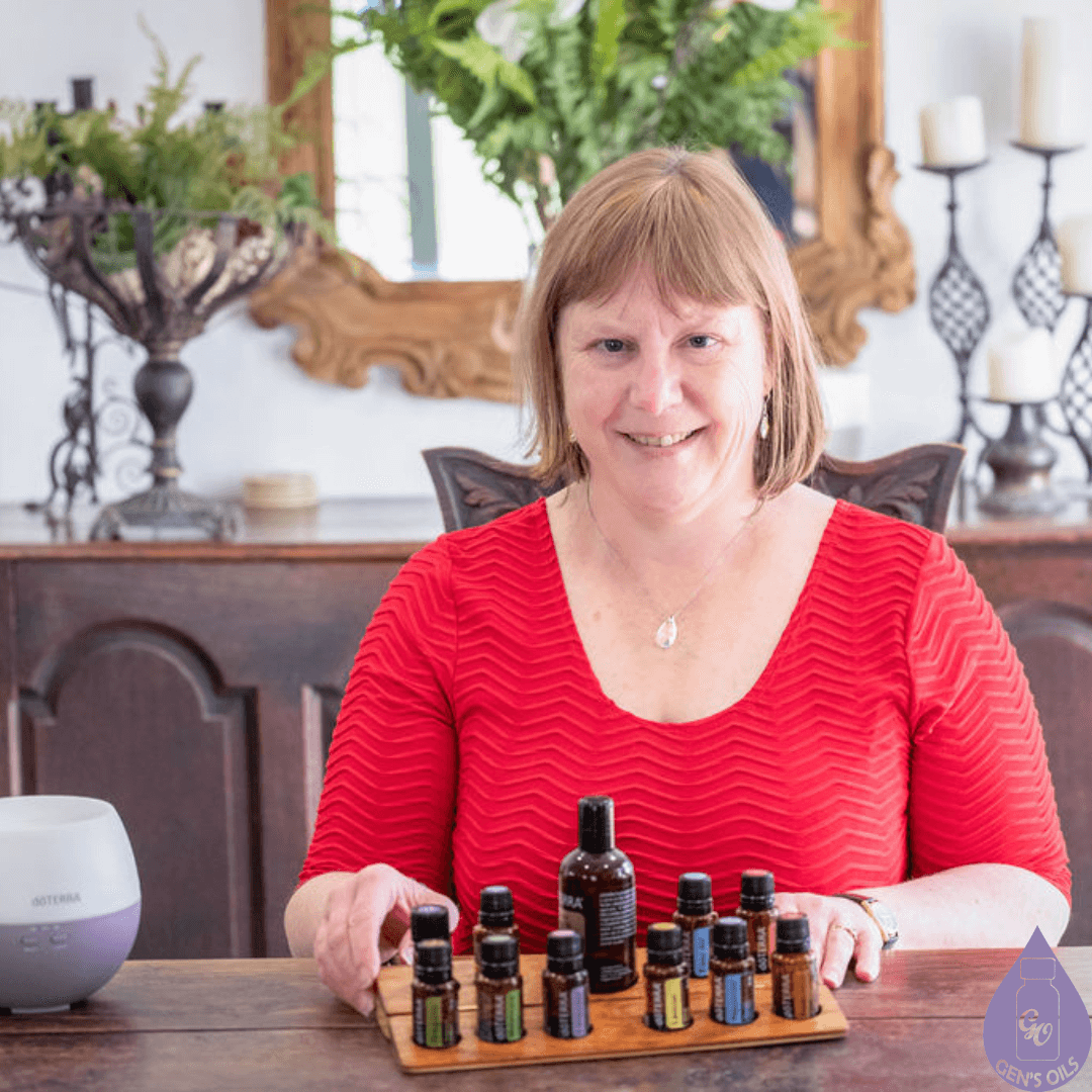 Genevieve sitting at a table with essential oils in a stand. A diffuser is off to one side.