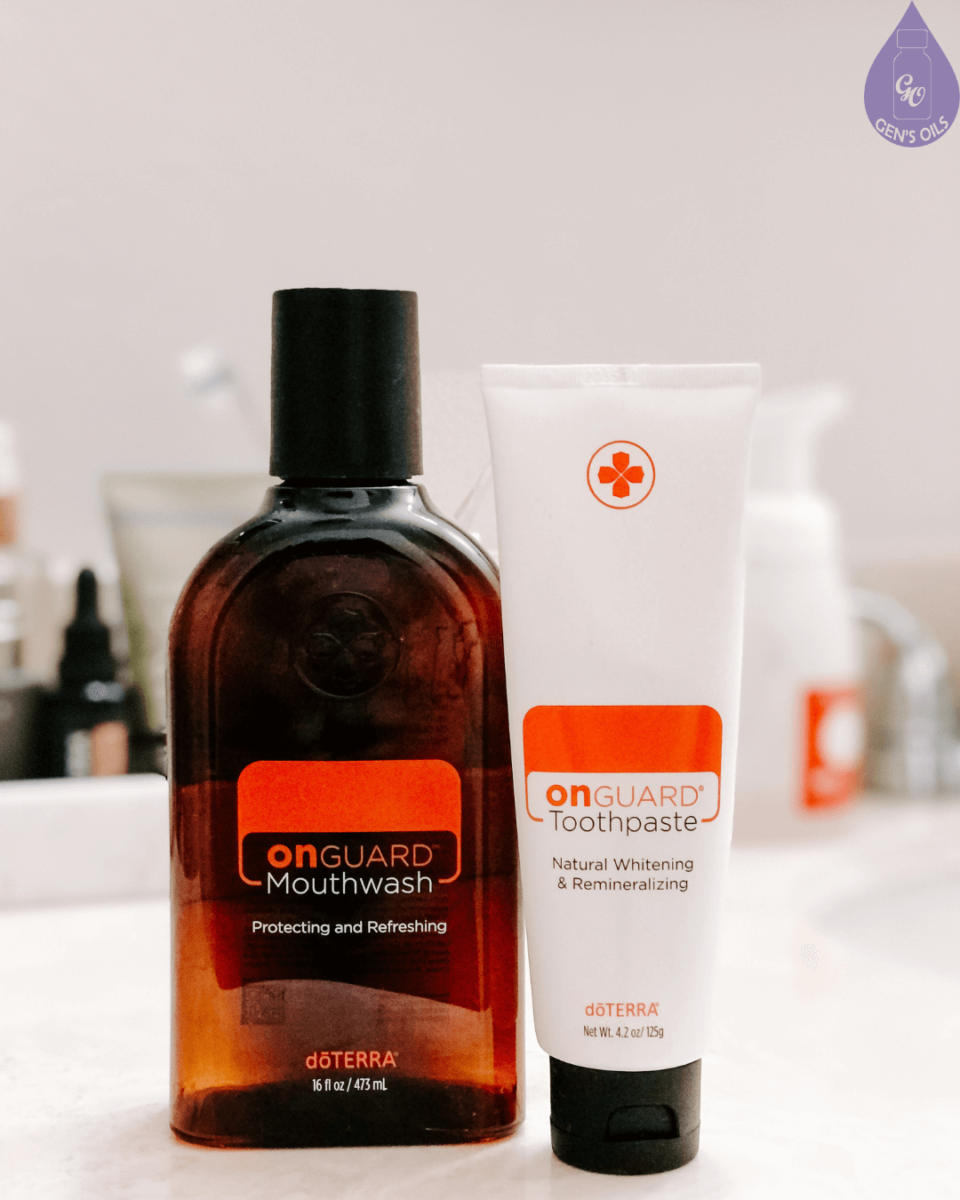 A bottle of OnGuard Mouthwash and a tube of OnGuard Toothpaste are displayed on a countertop.