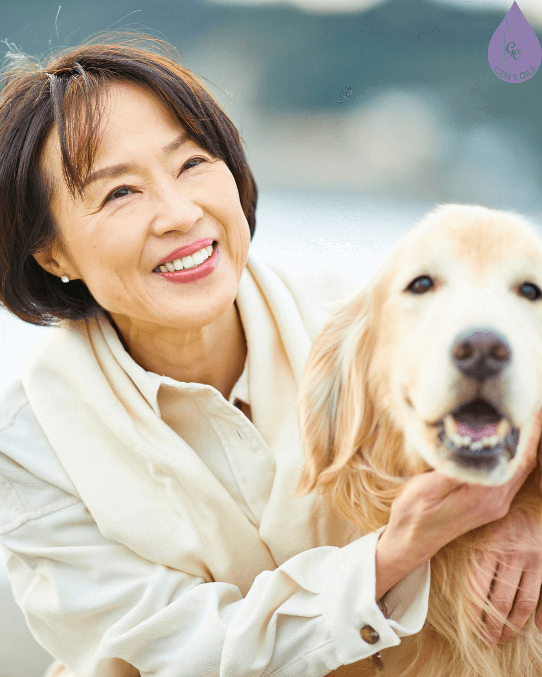 A smiling person hugs a golden retriever outdoors.