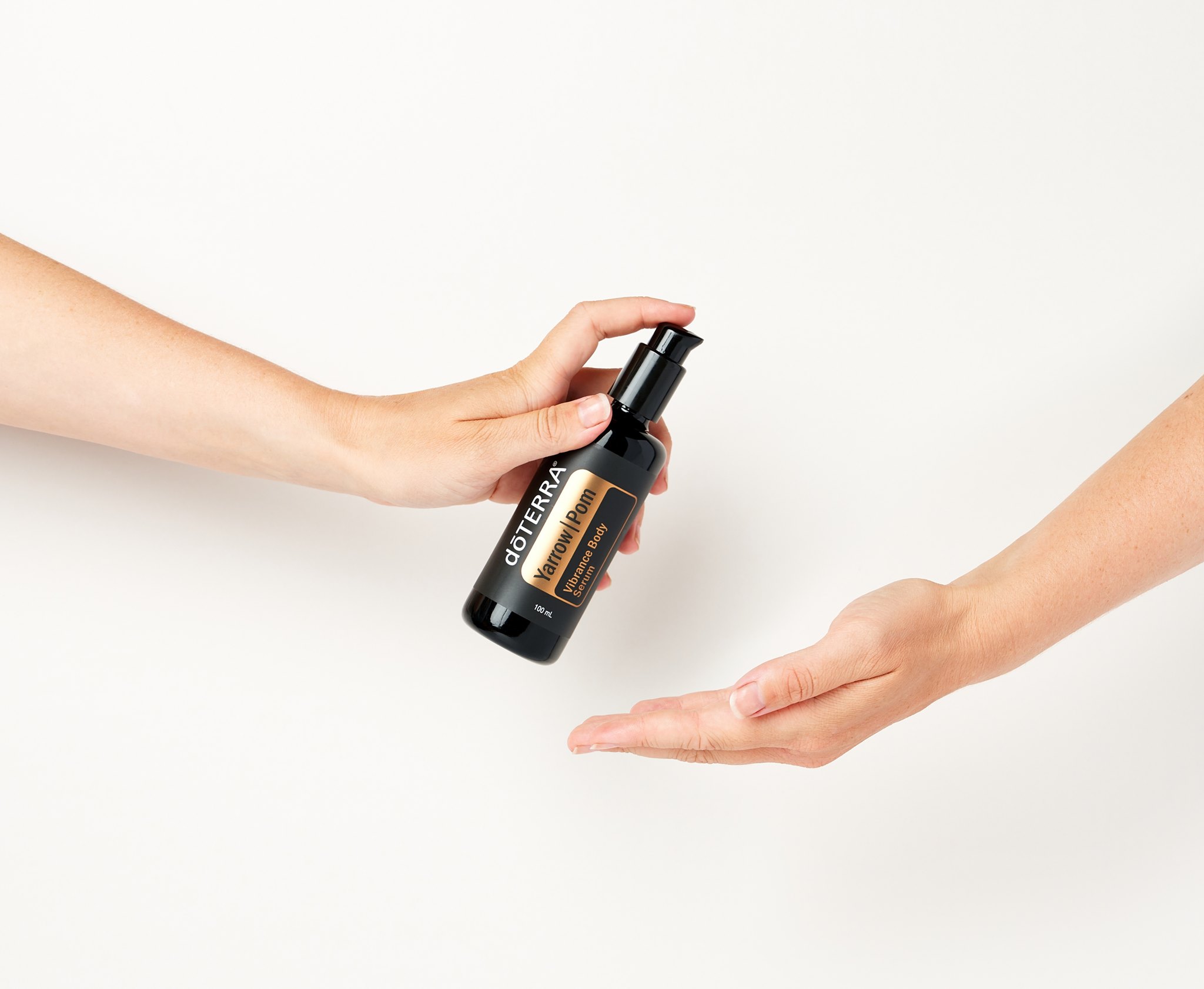 Spraying Yarrow Pom Vibrance Body Serum onto the skin