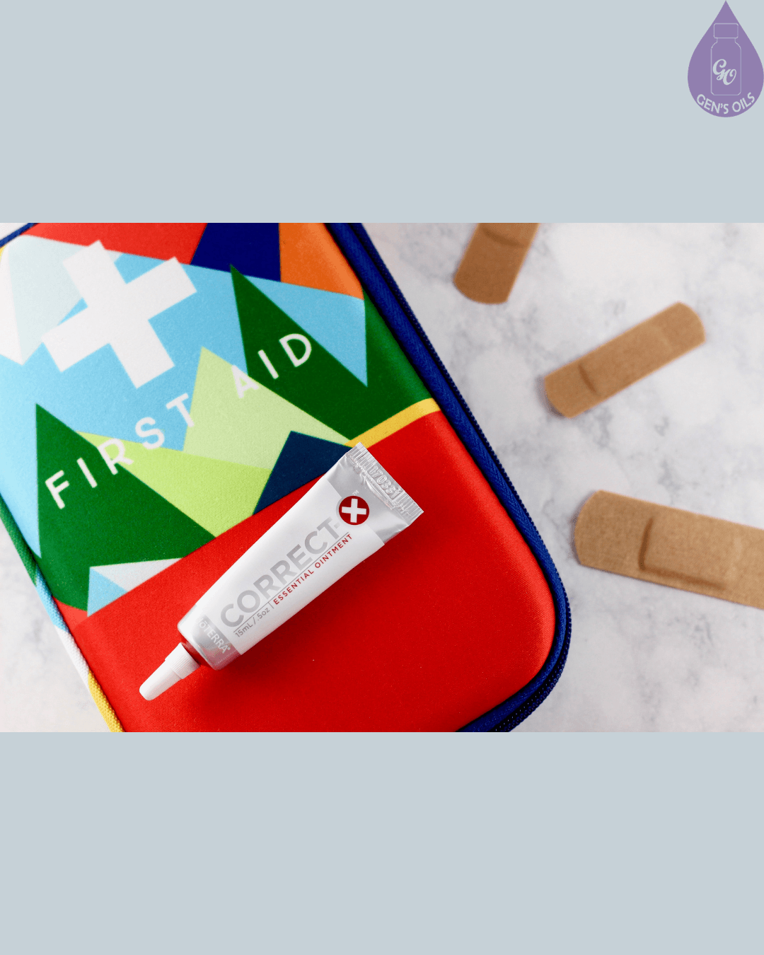 A colorful first aid kit with a tube of "Correct Essential Ointment" and several bandages on a marble surface.