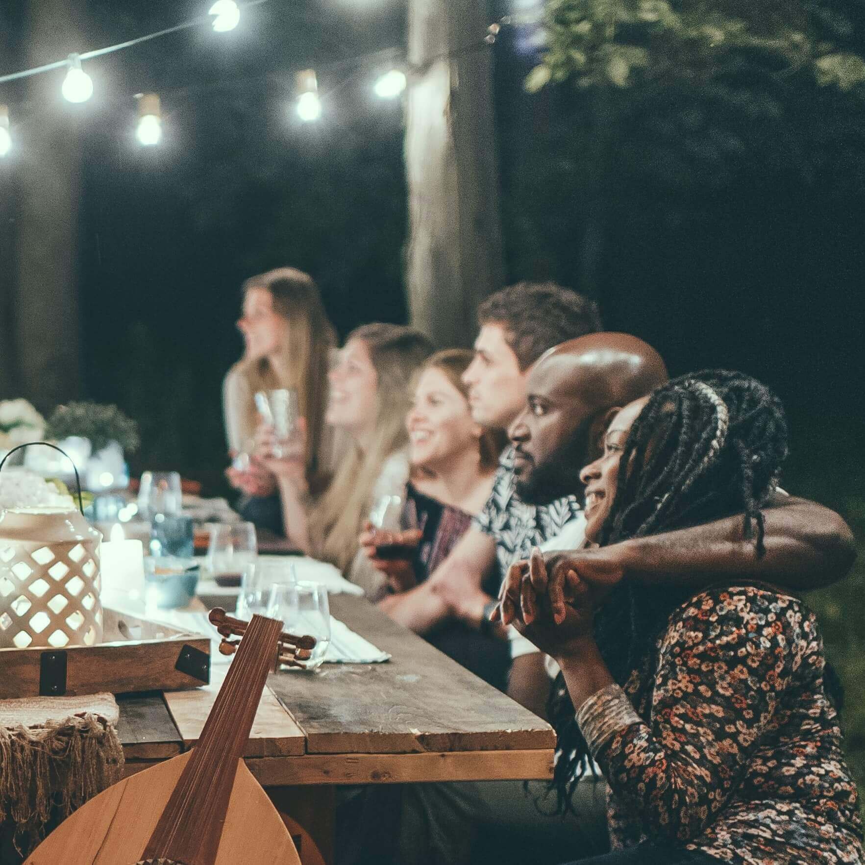 diverse people sitting around an outdoor table 