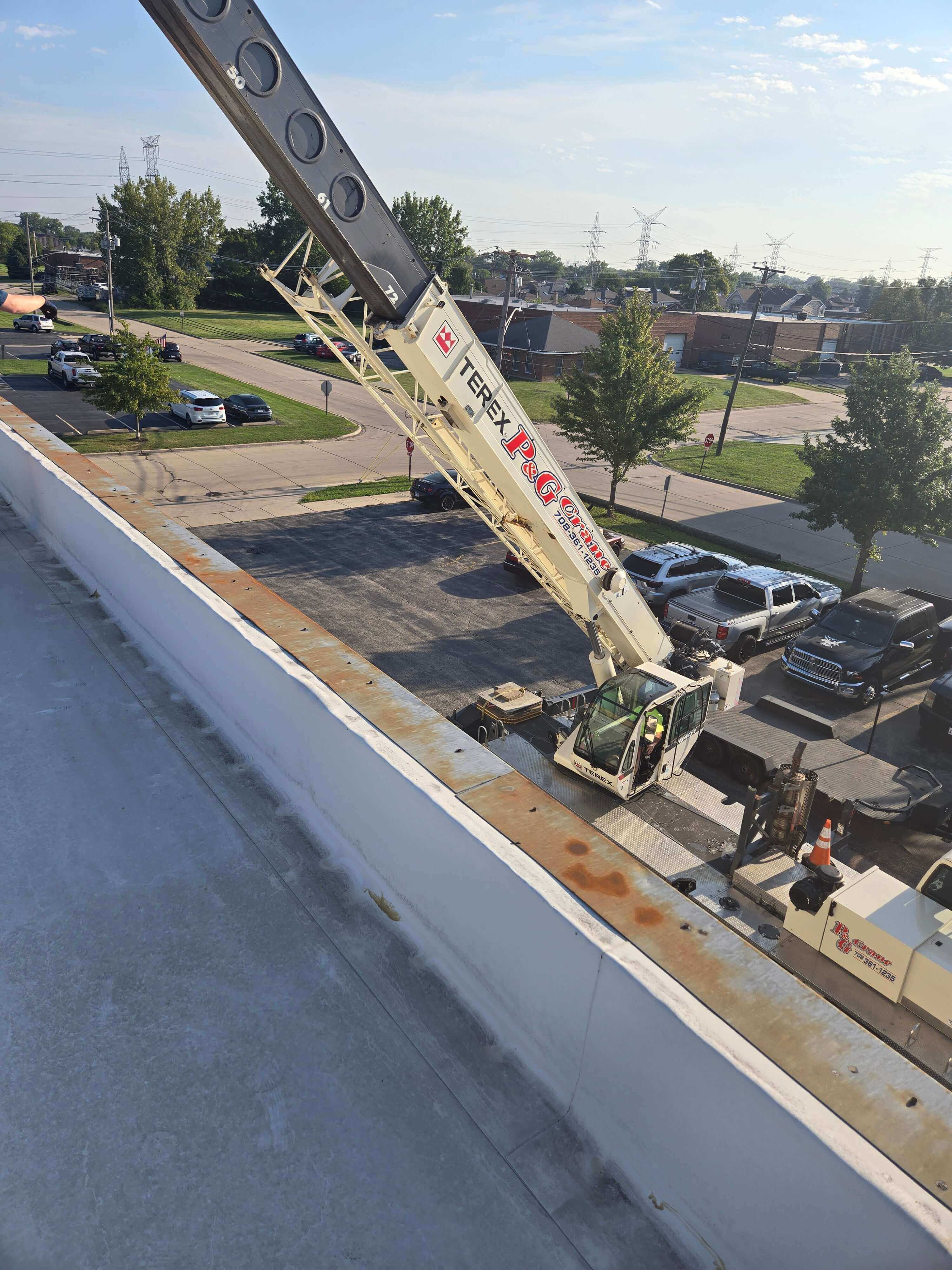 Crane boomed up next to a building.