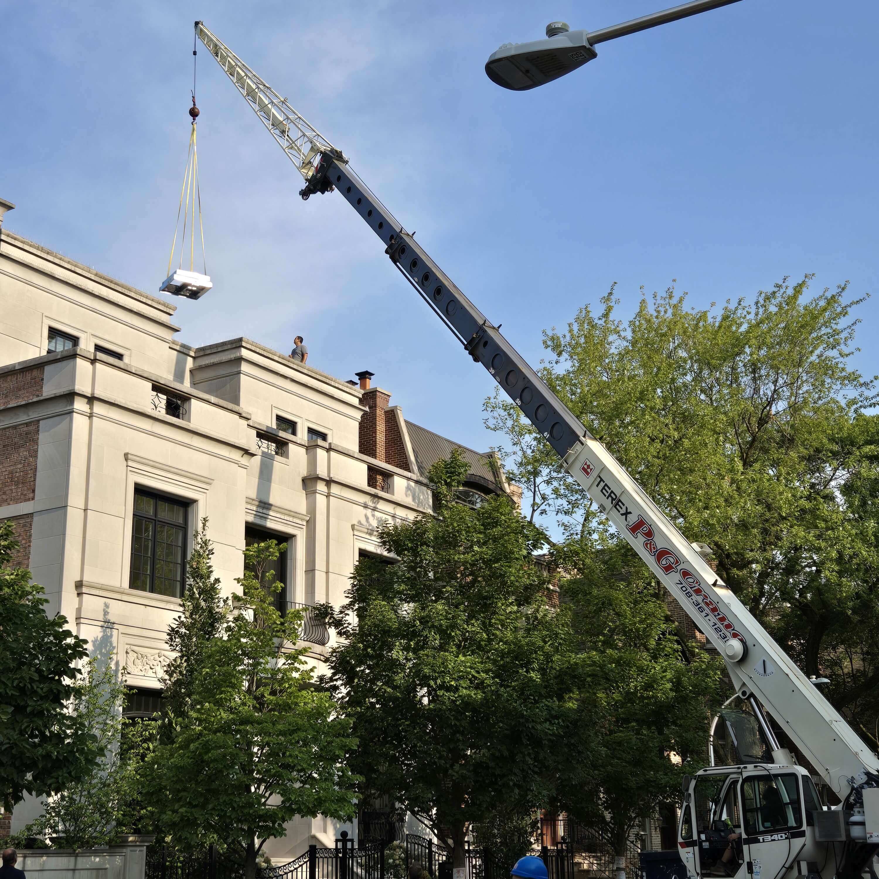 Crane lifting a unit over a building.