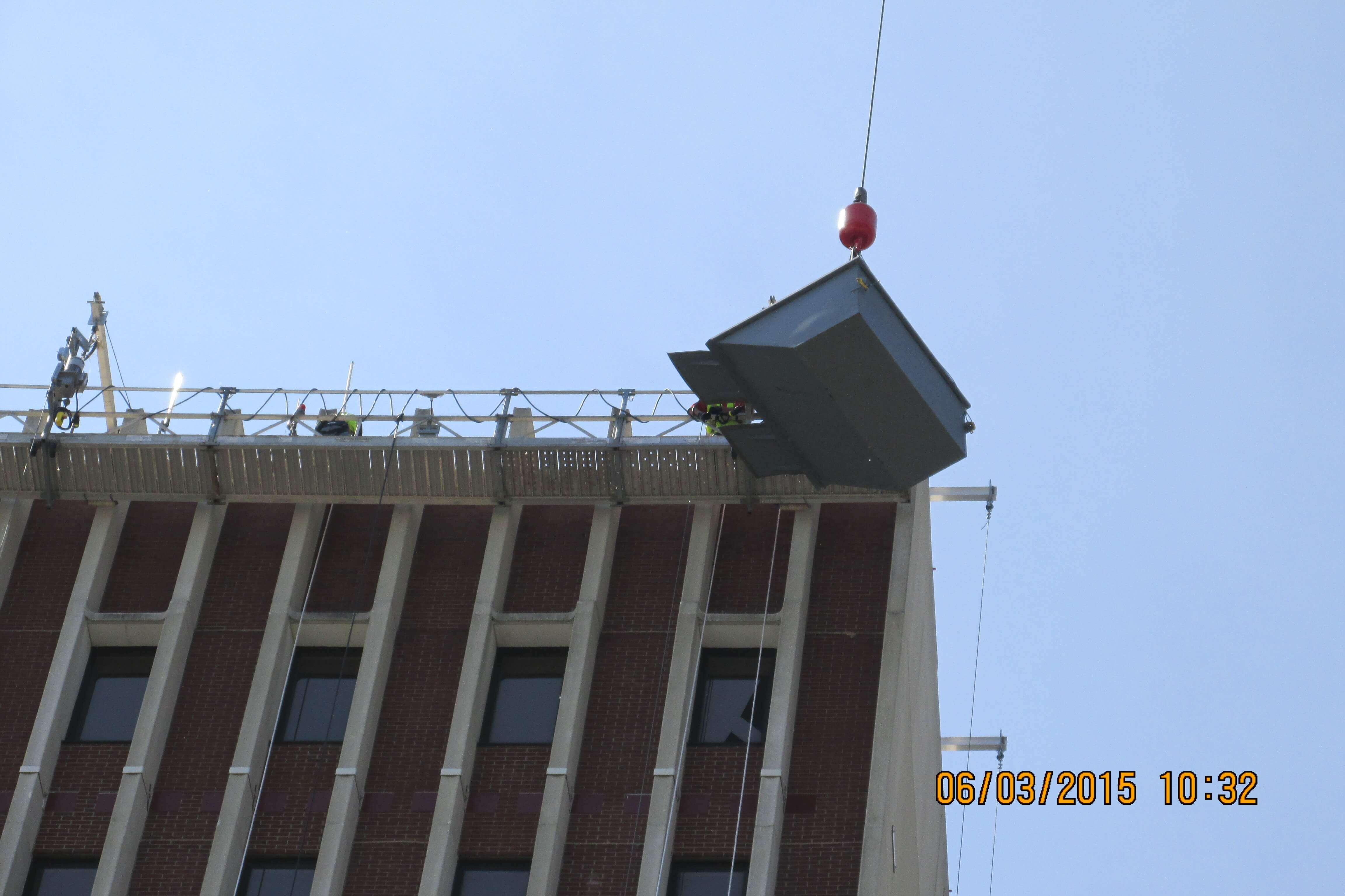 Crane lifting up a unit next to hospital.