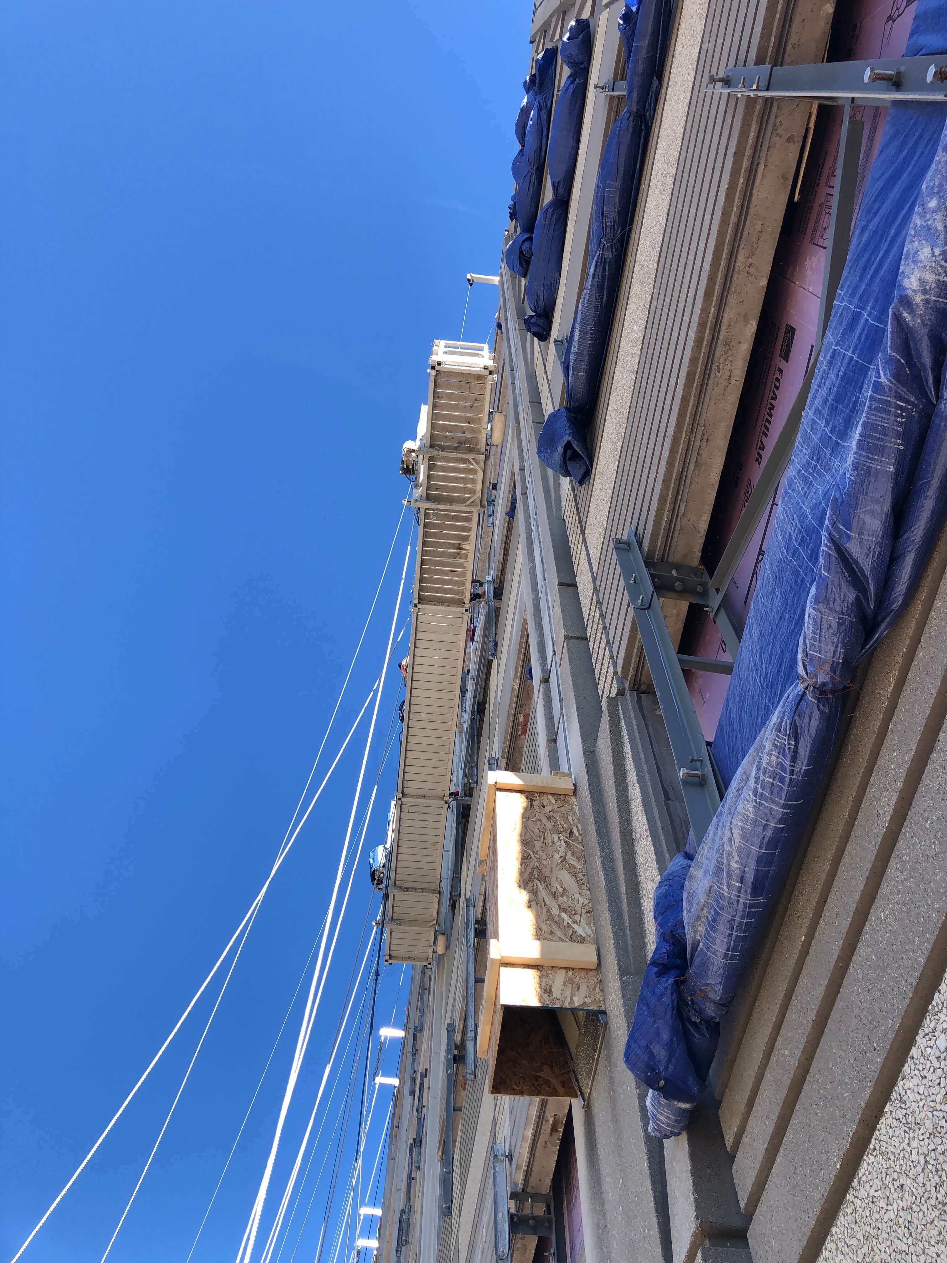 Under view of scaffolding on the side of a building under construction.