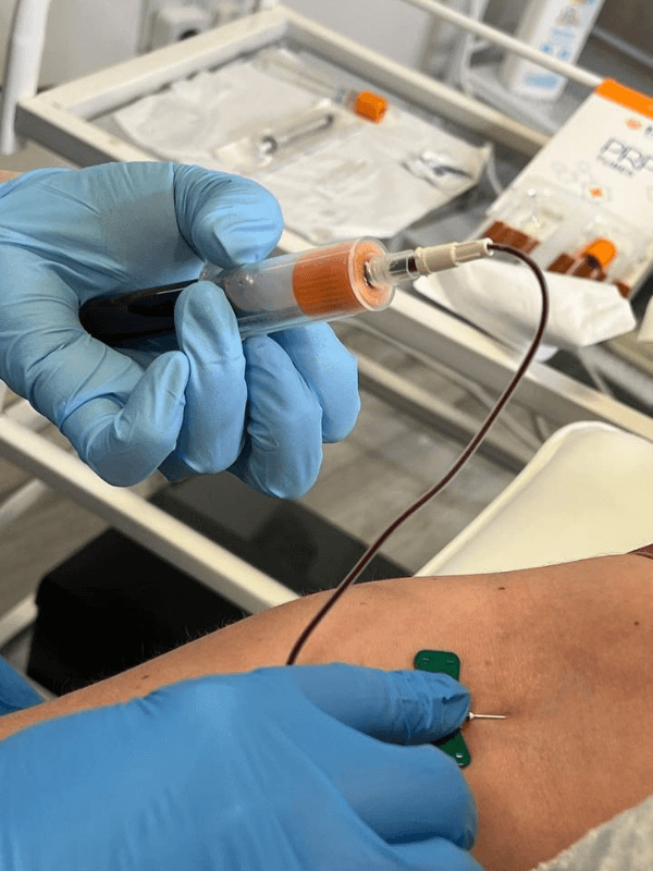 "Helena drawing blood from a client’s arm to prepare platelet-rich plasma for skin rejuvenation therapy at her Middlesbrough clinic."